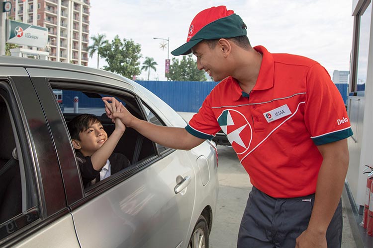 boy in car at caltex station forecourt