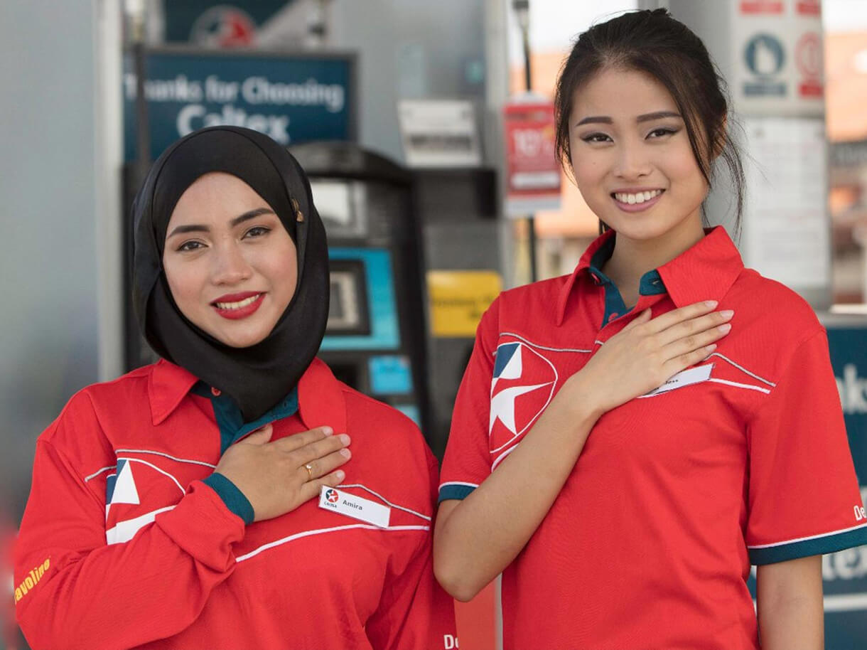 Two smiling female Caltex station attendants