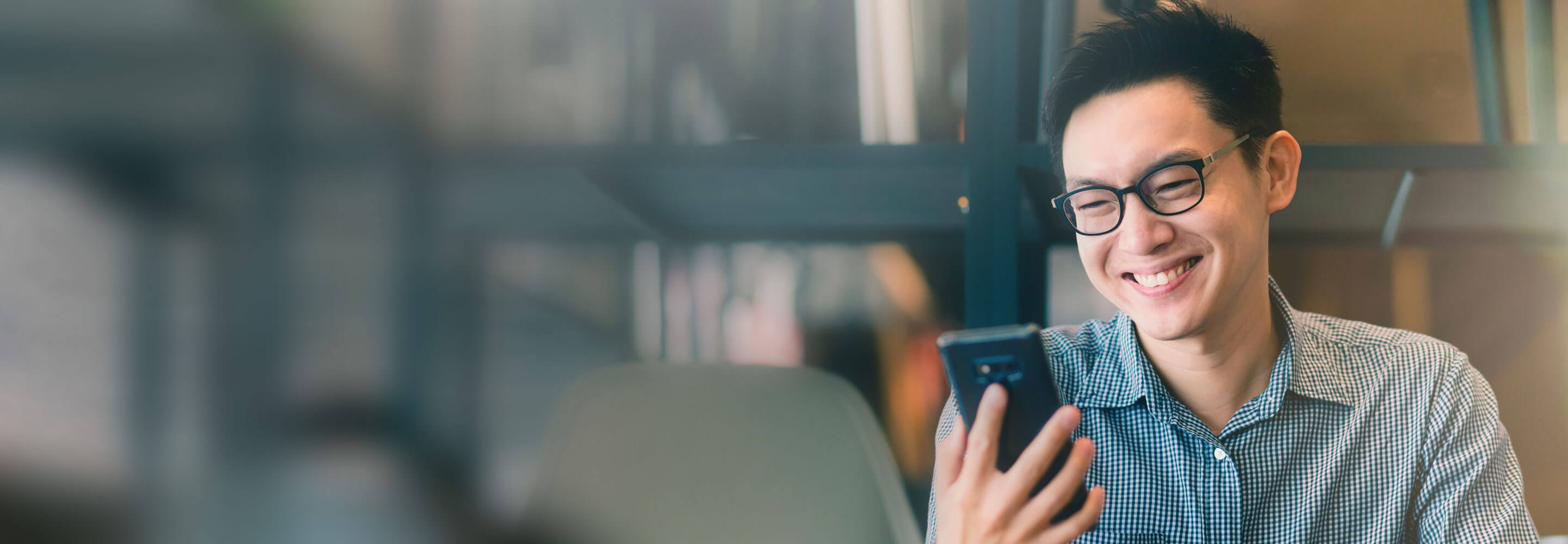 Man smiling while using mobile phone