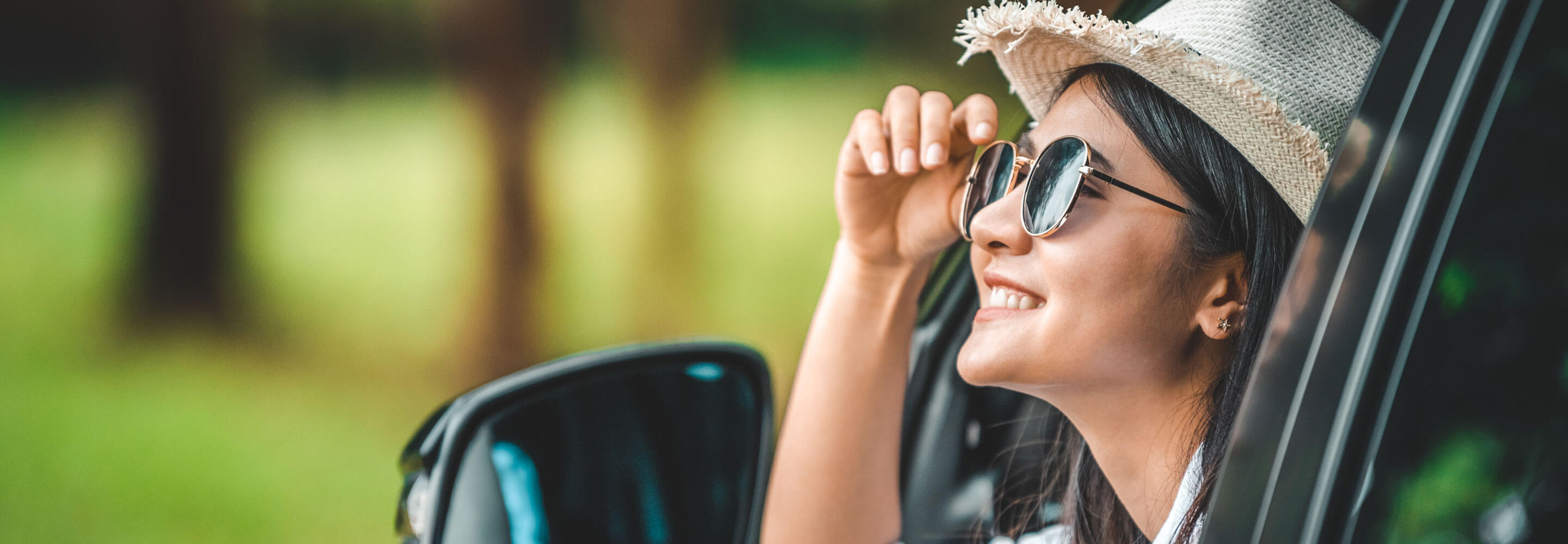 Woman with sunglasses looking out of her car window