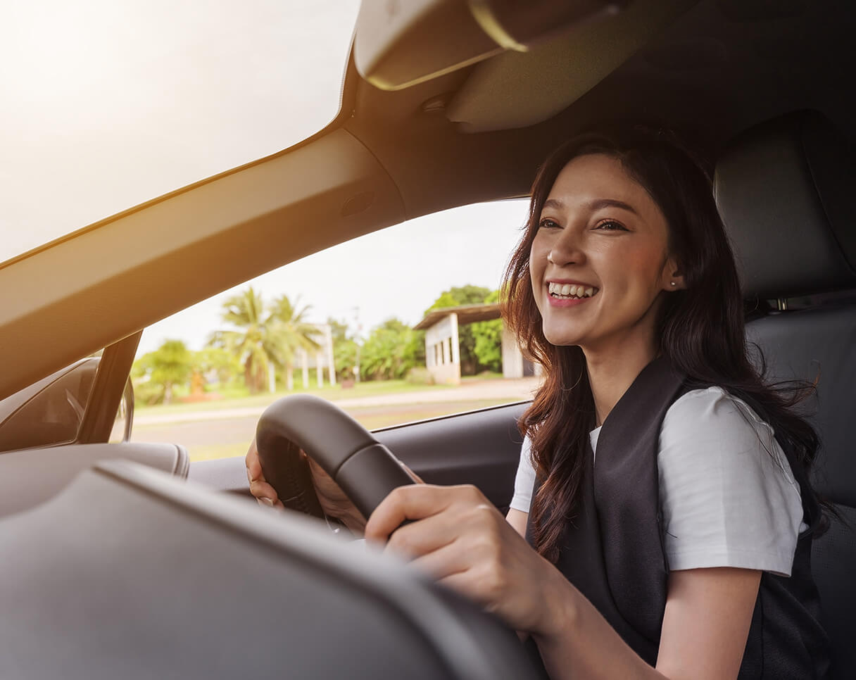Woman smiling while driving her car