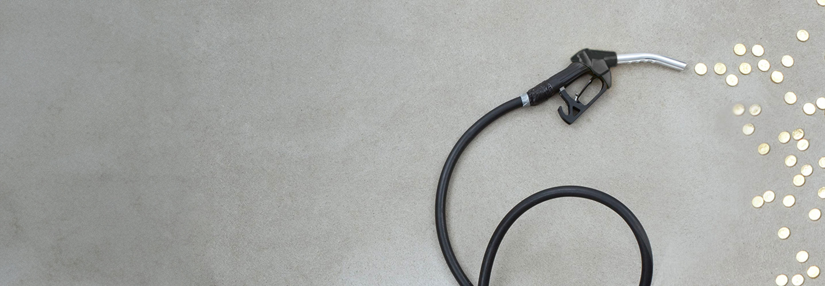 Black fuel nozzle and coins on the ground