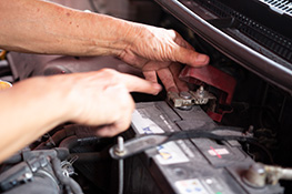 Hands inspecting a car engine