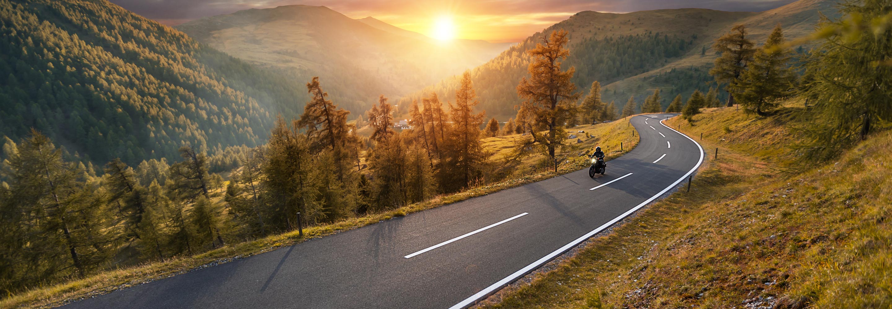 Motorcycle rider on a long mountain road